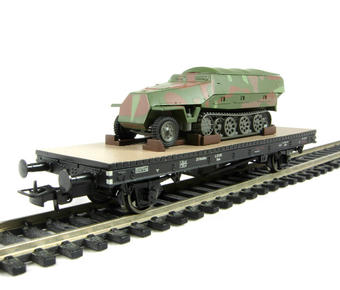 Type Omm 2 axle flat wagon of the German DR with Schutzenpanzer half track tank load in military camouflage - Epoch II