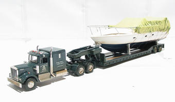 Kenworth W925 truck with lowboy trailer and boat load